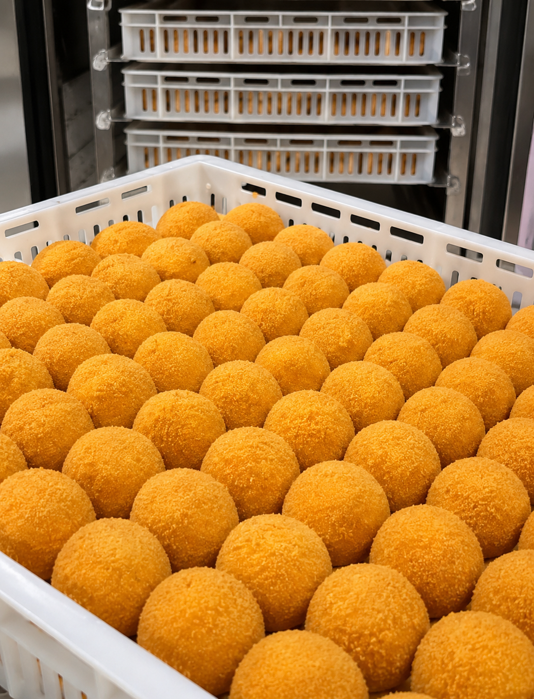 Salgados organizados em bandejas durante a produção